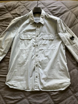 Cp.company overshirt - Säljer nu en snygg ljusblå overshirt från cp.company, den är nästintill oanvänd alltså grymt bra skick. Perfekt nu till sen sommar/höst. Bara hör av er om ni har frågor Mvh