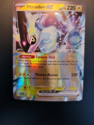 Miraidon ex Pokémonkort holografiskt - Säljer ett holografiskt Miraidon ex Pokémonkort med el-typ från Scarlet & Violet-serien. Kortet har färgstark design med guld, blått och lila och visar Pokémonen Miraidon. Perfekt till samlingen eller för spelkvällar med vänner.