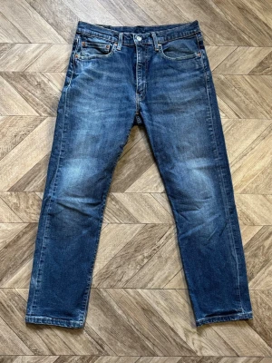 Levi's 540 - Säljer ett par blå jeans med rak passform och fem fickor. Jeansen har en klassisk look med lätt slitningar och kontrastsömmar. Tillverkade i denim med knappgylf och bälteshällor. Perfekta för en avslappnad stil.   Längd 98cm Bredd 41cm