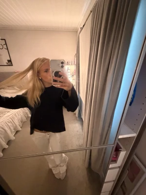Mörkblå stickad tröja - En mörkblå stickad tröja med rund hals och långa ärmar. Tröjan har en enkel, clean design utan synliga loggor eller mönster.