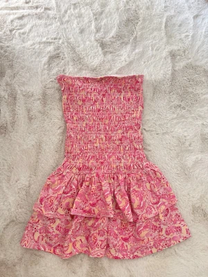 Rosa bandeauklänning  Gina Tricot - Supersöt bandeauklänning från Gina Tricot i rosa med mönster! Den är använd fåtal gånger och är i storlek xs