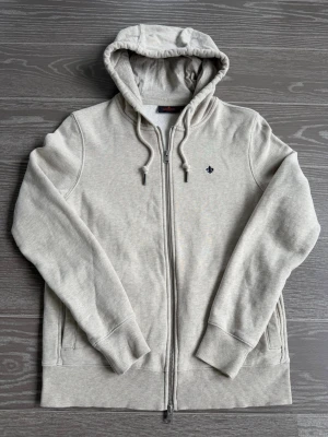 Morris hoodie  - Beige Morris helzip i storlek XS. Använd ett fåtal gånger och har därmed inga defekter eller skador. Hör gärna av dig vid frågor.