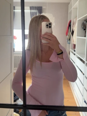 Ljusrosa långärmad topp Gina Tricot - Säljer en ljusrosa långärmad topp med slits på ärmarna från Gina Tricot. Toppen har en rundad, lite djupare urringning och är i ett mjukt, stretchigt material💕 
