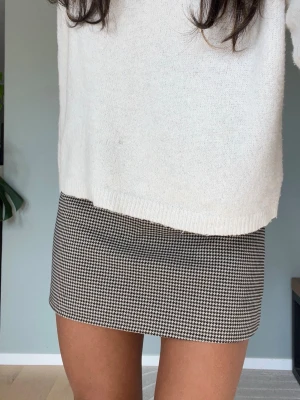 Rutig kortkjol i svart och beige - Höstkjol. 