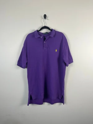 Vintage Polo Ralph Lauren Piké L Lila Purple 100% Bomull 90s Y2K Retro Herr - • Storlek: L • Färg: Lila • Passform: Classic Fit  • Krage: Klassisk pikékrage • Material: 100% bomull  Skick: Plagget är i väldigt fint skick med lite blekningar som syns på bild. Eventuella anmärkningar anges alltid tydligt i beskrivningen och visas på bilderna.  Nypris: Cirka 1 400 kr.  📦 Skickas snabbt och packas omsorgsfullt. 💬 Hör gärna av dig om du har frågor eller vill se fler bilder. 🤝 Samfrakt erbjuds vid köp av flera plagg – kika gärna in mina andra annonser!