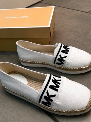 Micheal kors skor - Helt nya super fina vita espadrillos från Michael Kors med svart logotypband. Skorna har en flätad sula och en bekväm, ribbad yttersula.  Köpt i Micheal kors butik. (Helt oanvända och nya ) kartongen medföljer.