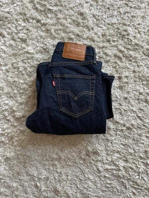 Mörkblå Levi's 511 jeans - Säljer ett par mörkblå Levi's 511 jeans i klassisk slitstark denim. Jeansen är oanvända då jag köpte för små och inte längre passar 