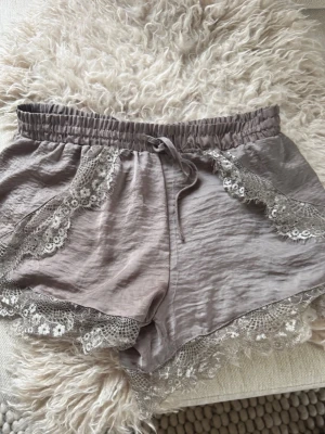Grå spetsdetaljerade shorts Neo Noir - Supersnygga grå loungewear-shorts från Neo Noir med bred resår i midjan🩶