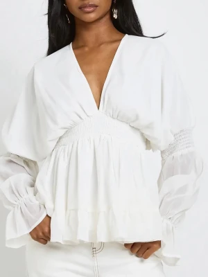 Vit blus med v-ringning och volanger - Säljer en vit blus med djup v-ringning fram och bak, smock i midjan och volangdetaljer. Blusen har långa, transparenta ärmar med smock vid armbågen och knytband i nacken. Perfekt för en trendig och chic look. Säljer pga för liten