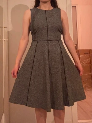 Klänning - Klänning i tjockare tyg, så perfekt till hösten. Elegant och stilig som sitter åt vid överdelen och svänger ut nertill. Passar storlek M-L, jag bär vanligtvis st. M