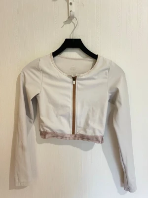 Vit träningströja från aimn - Snygg vit träningströja med lång ärm och dragkedja framtill från aimn i storlek S. Toppen har en tight passform och är perfekt för dig som gillar trendiga och stilrena plagg. Materialet känns mjukt och stretchigt, vilket gör den bekväm att bära.
