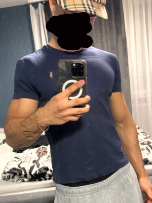 Mörkblå t-shirt från Polo Ralph Lauren - Säljer en mörkblå t-shirt från Polo Ralph Lauren med den klassiska broderade loggan på bröstet. T-shirten har rund halsringning och korta ärmar. Perfekt basic-plagg som funkar till allt och är riktigt skön tack vare mjukt bomullsmaterial.