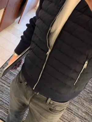 Mörkblå cardigan - Snygg mörkblå cardigan jacka med quiltad design och två dragkedjeförsedda fickor och midja samt hög krage. Perfekt för kalla vinterdagar och ger en modern look. Från elegance essentials. Skick 9/10