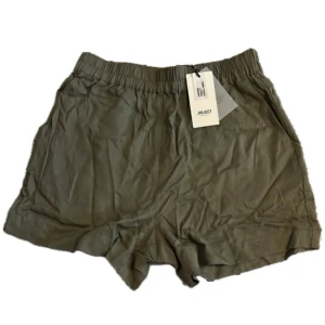 Gröna shorts från Object - Snygga gröna shorts från Object med elastisk midja och avslappnad passform. Perfekta för varma dagar och enkla att matcha med olika toppar. Tillverkade i ett mjukt och lätt material som känns skönt mot huden.
