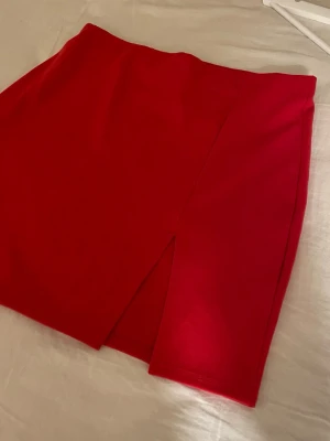 Röd kort kjol - Köpt på Nelly i storlek M med en slits, väldigt stretchigt material