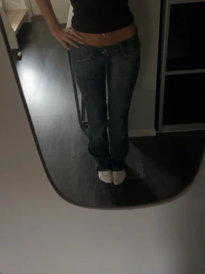 Mörkblå bootcut jeans låg midja - Säljer ett par mörkblå diesel bootcut jeans med låg midja och  fem fickor. Jeansen har en lätt tvättad look och sitter tajt över höfterna för en snygg siluett. Perfekta för dig som gillar en Stockholms stil vibe och vill ha ett par jeans som sticker ut. Byxorna har storlek S