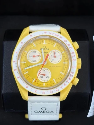 Omega x Swatch MoonSwatch gul klocka - Säljer en Omega x Swatch MoonSwatch Mission to the Sun. Klockan har en gul boett och urtavla med vita och röda detaljer samt vit textilrem med Omega-logga. Snygg och unik design från Bioceramic MoonSwatch Collection.