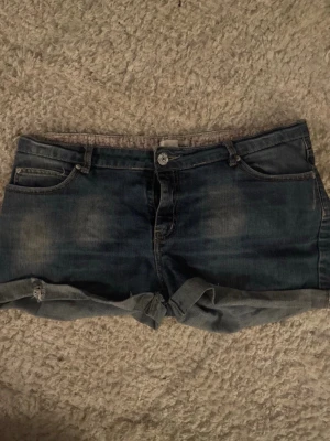Mörkblå jeansshorts  - Säljer ett par mörkblå jeansshorts med fina små detaljer på fickor och insida. Shortsen är ifrån ”by ellos”. Perfekta för varma dagar. Priset går att diskutera! Sitter mer som 38-40 i storlek!❣️