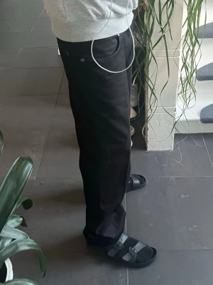Svarta raka raw denim jeans - Säljer ett par raka/baggy svarta raw denim jeans. Jeansen är i bra skick och väldigt bra kvalitet. Jeansen har silverfärgade knappar och nitar samt bälteshällor. Materialet är denim med en matt finish, kan vara selvedge denim men osäker. Ser ut som det iallafall. Vet inte riktigt storleken på de men det står 50. Jag är 175 och de är lite för långa för mig. Passar snyggt med t.ex ett svart/brunt läderbälte och en stilren hoodie men de är lätta att styla. Helt perfekt till hösten!