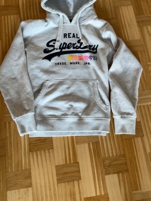 Superdry hoodie  - Säljer nu denna riktigt schyssta super dry hoodien! till ett suveränt pris🤩 väldigt snygg, varm, tjock och skön att bära! passar med nästan allt😁 priset är diskuterbart och jag fraktar inom 8 h! hör av er vid minsta fundering 