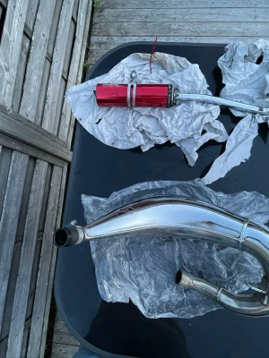 Rött Voca racing rör till moped  - Säljer ett voca racing avgassystem till moped med ett kromat rör och en röd ljuddämpare. Riktigt bra trimrör som funkar för cross mopeder 