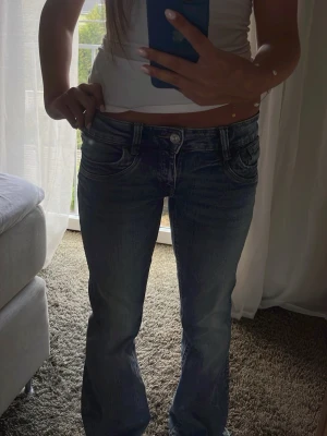 Blå bootcut jeans - Säljer ett par lågmidjade bootcut jeans ifrån Gina Tricot!!🤗 Jeansen är endast använda ett fåtal gånger💕 Storlek 164 
