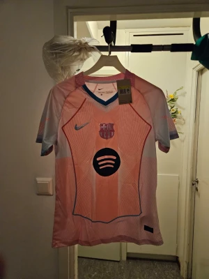 Barça matchtröja rosa Nike S - Säljer en rosa FC Barcelona matchtröja från Nike med Dri-FIT-material. Tröjan har klubbmärke, Nike-logga och Spotify-logga på bröstet samt blå detaljer vid kragen. Perfekt för dig som älskar fotboll och vill sticka ut på planen.