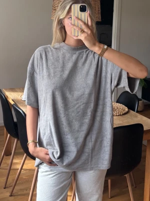 T-shirt  - Oversized T-shirt i towelling / frotté / terry material, med hög neckline. 