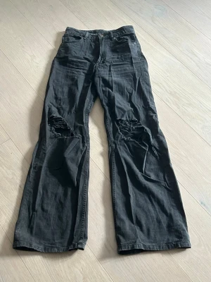 Svarta jeans med vida ben - Svarta jeans med hål vid knäna. Från H&M och är i storlek 36/S💕