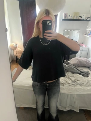 Svart croppad topp med vida ärmar - En svart croppad topp med lös passform och vida, halvlånga ärmar. Är använd men ser ut som nyskick är storlek Xs men passar S/M med då den är töjbar.
