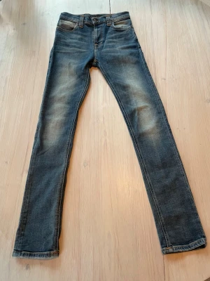 Blå slim fit jeans - Snygga blå slim fit jeans med lätt slitna detaljer på låren och knäna. Storlek W27 L30