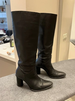 Svarta knähöga läderstövlar - Säljer min absoluta favoritboots från Zara då jag inte längre får användning av dem. Äkta läder, spetsig tå och rund klack. Klackhöjd 7,5 cm. Otroligt sköna att gå i och väl omhändertagna. Går självklart att fräschas upp med läderputs 🫶 