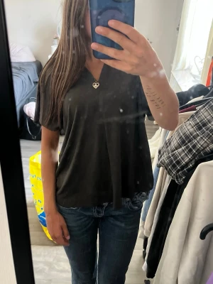 Svart v-ringad t-shirt - En enkel svart t-shirt med v-ringning och korta ärmar. T-shirten har en loose passform och är tillverkad i mjukt bomullsmaterial. Perfekt till jeans eller shorts för en avslappnad look.
