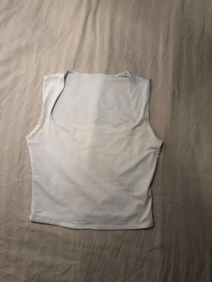 Vit linnetopp - Säljer en enkel och stilren vit linnetopp. Toppen är croppad och är stretchig  som passar perfekt till jeans eller kjol. Perfekt för varma dagar eller som lager under en skjorta.