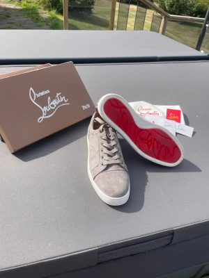 Gråa Louboutins - Snygga gråa Louboutins, knappast använda, box, duk och alla kort tillkommer, finns ej kvitto