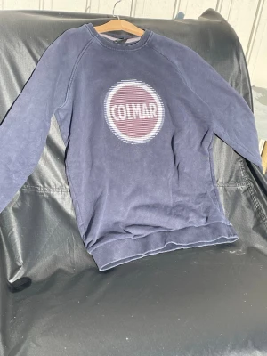 Mörkblå sweatshirt från Colmar - Mörkblå sweatshirt från Colmar och stort tryckt Colmar-logo i vitt och vinrött. Det står 14yo/166cm men den är typ 157cm!