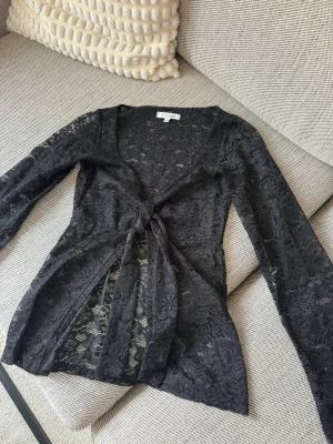 Svart spetsblus med knyt framtill - Snygg svart långärmad spetsblus från Design by si med knyt framtill. Skriv vid funderingar 🥰