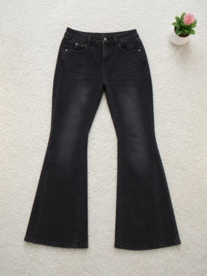 Svarta utsvängda jeans med hög midja - Snygga svarta flare jeans med utsvängda ben och hög midja. Klassisk femficksmodell och knappgylf. Jeansen har en lätt tvättad look och är tillverkade i stretchigt denimtyg som sitter bekvämt. Perfekta för en trendig och avslappnad stil. Från Shein. 34 | W26