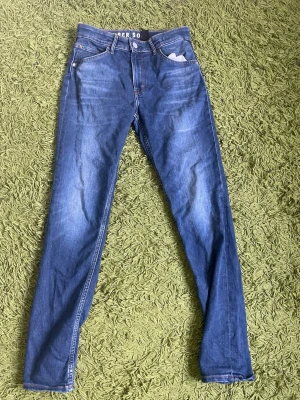 Blå skinny jeans med zigzag-detalj - Snygga blå skinny jeans med klassisk femficksmodell och cool zigzag-detalj på bakfickorna. Jeansen har normalhög midja och smal passform hela vägen ner. Perfekta till en avslappnad streetstyle-look.
