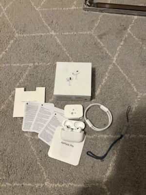 Apple AirPods Pro (2nd gen) med tillbehör - Säljer ett par vita Apple AirPods Pro (2nd generation) med laddningsetui, USB-C kabel, extra öronproppar, originalförpackning och alla extra grejer. Snygg och stilren design i plast, perfekt för dig som vill ha grymt ljud och brusreducering. Allt som behövs för att komma igång direkt! Airpodsen är knappt använda ungefär 5-6 gånger så dem är som nya. Tveka inte att fråga om du har någon fundering 😀