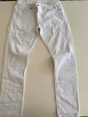 Vita jeans från Dondup - Säljer ett par vita jeans från Dondup. De har klassisk femficksdesign, normal passform och är tillverkade i ett mjukt jeansmaterial. Perfekta för dig som vill ha en clean och stilren look.                  MODELL: GEORGE 34, passar 32-34 utan tvekan!
