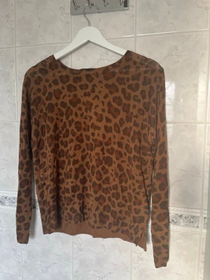 Leopardmönstrad brun stickad tröja - Brun långärmad topp med leopardmönster och rund halsringning. Tillverkad i ett mjukt och stretchigt material som sitter skönt på kroppen. Perfekt för dig som vill ha en unik topp, köpt på zara i Rom, Italien🤎