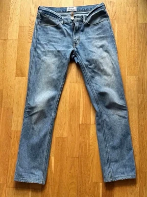 Acne Jeans - Säljer ett par klassiska blå jeans från Acne Studios, modell Max LT Vintage 30x34. Jeansen har rak passform, tillverkade i 100% bomull. Snygg tvätt med lätt slitning på låren för en vintagekänsla.
