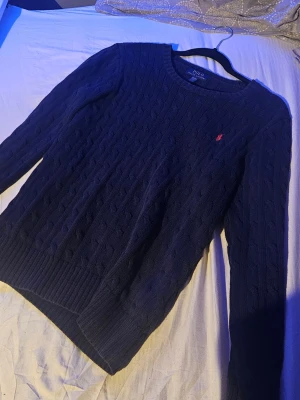 Mörkblå stickat Ralph Lauren tröja - Stickat Ralph Lauren tröja i mörkblå färg i väldigt bra skick utan några deffekter. Passar bra på mig och jag änvänder storlek S. OPS! Jag kan bara skicka med PostNord.