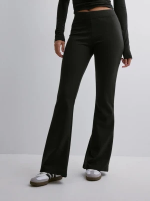Svarta utsvängda leggings - Säljer ett par svarta leggings med utsvängda ben och hög midja. De är tighta upptill och har en snygg, enkel design utan synliga detaljer. Perfekta för dig som gillar en stilren och trendig look. Materialet ser stretchigt och bekvämt ut.
