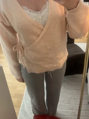 Ljusrosa omlottkofta med knytband - Jättesöt ljusrosa omlottkofta från Lindex. Färgen är lite otydlig på bild men koftan är lax rosa! Storlek S. Pris går såklart att diskutera💗