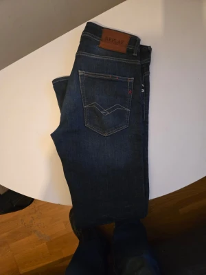 Mörkblå jeans från Replay - Snygga mörkblå jeans från Replay med klassisk femficksdesign och raka ben. Jeansen har en läderpatch med logga bak i midjan och kontrastsömmar. Perfekta till vardagslooken och tillverkade i slitstarkt denimtyg.