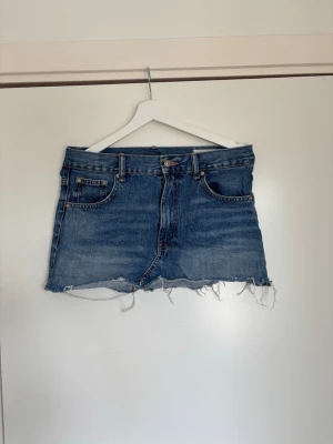 Blå jeanskjol med fransig kant (Zara) - En jättefin blå jeanskjol från Zara som knappt är använd.