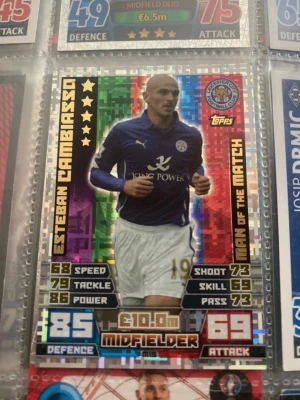 Esteban Cambiasso "Man of the Match" Match Attax-kort från Leicester City. - Kortet ligger i plastficka, vilket har hjälpt till att bevara det.  Hörn och kanter ser skarpa ut.  Ingen synlig böjning eller veck. * Folieytan ser fin ut, även om det kan finnas små repor som inte syns på bilden.