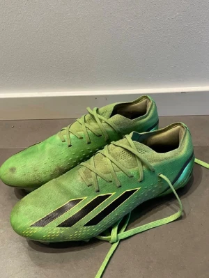 Adidas fotbollsskor - Säljer ett par gröna fotbollsskor från Adidas med svarta detaljer och snörning. Skorna har en modern design med dobbar för bra grepp på planen. Perfekta för fotbollsspelare som vill sticka ut. Skorna är i bra skick och är en av dem dyrare modellerna,nypris är runt 2300kr| bara höra av sig vid frågor! Storlek 40 o 2/3 men passar 40-41